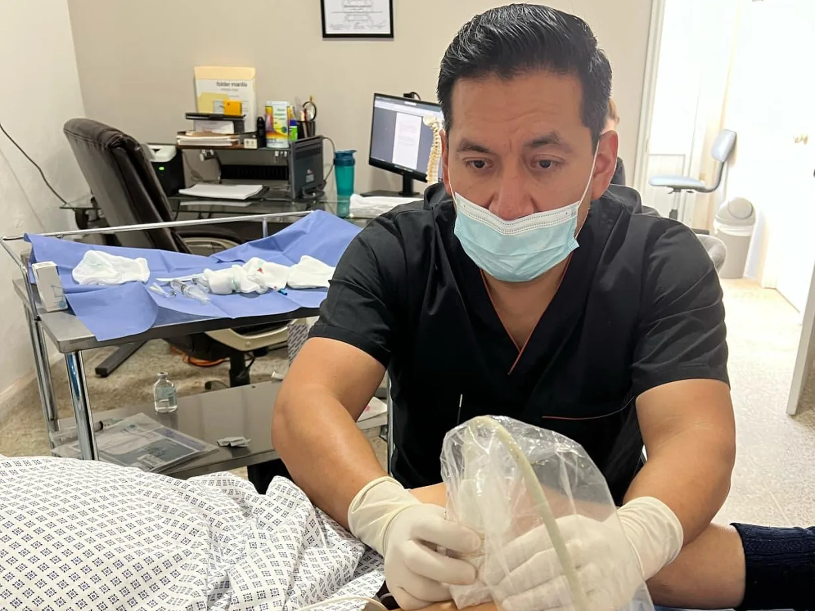 Dr. Hiram Medel realizando un bloqueo guiado por ultrasonido en consultorio