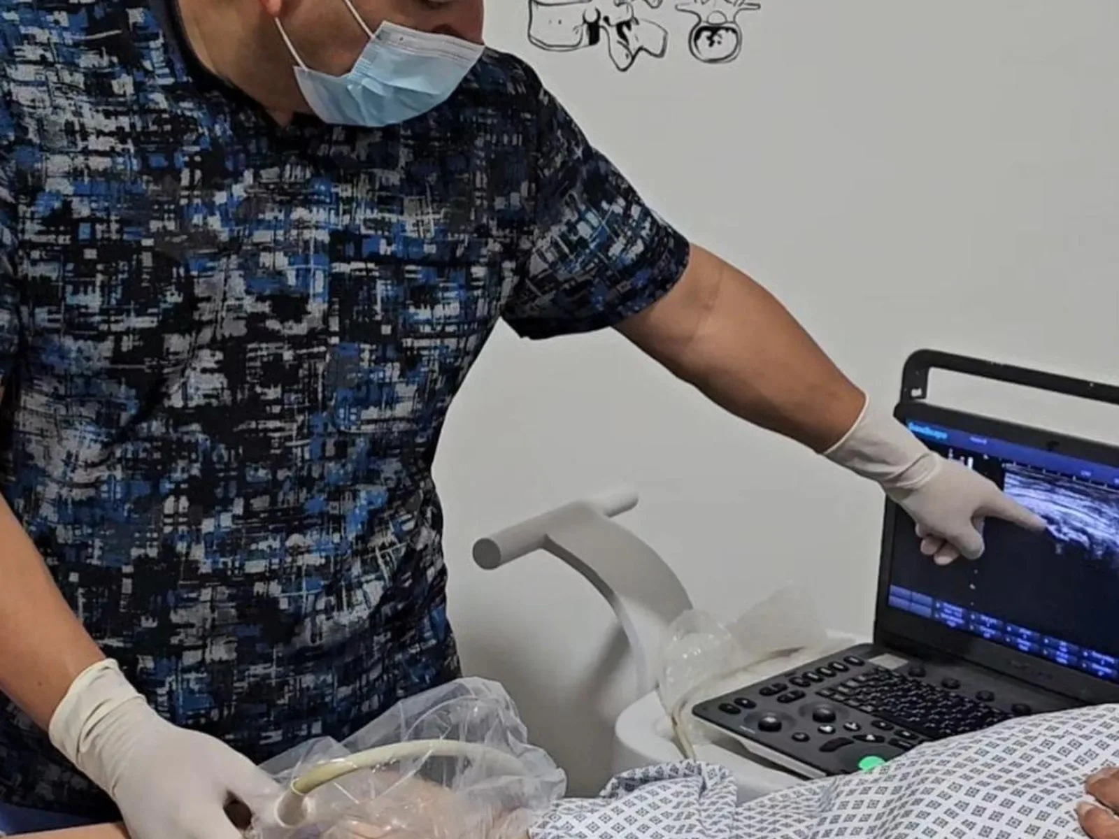 Dr. Hiram Medel revisando una imagen de ultrasonido en tiempo real durante la consulta